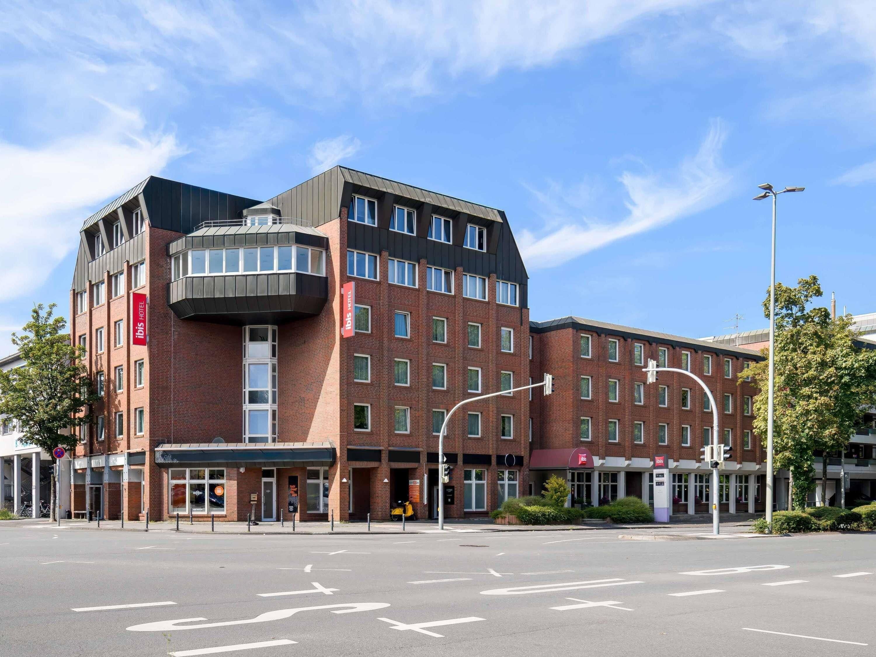 Ein modernes Hotel mit Ziegelverkleidung, mehreren Etagen und einem Hauseingang an einer Ecke.