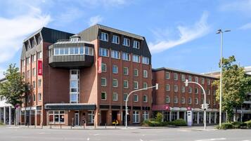 Ein modernes Hotel mit Ziegelverkleidung, mehreren Etagen und einem Hauseingang an einer Ecke.