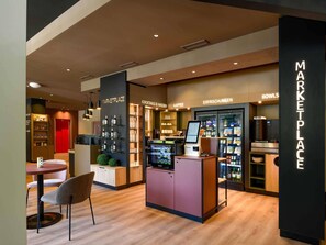 A modern marketplace with a kiosk, shelves of beverages, and a section labeled 'BOWLS'. - ibis Paderborn City (Paderborn)
