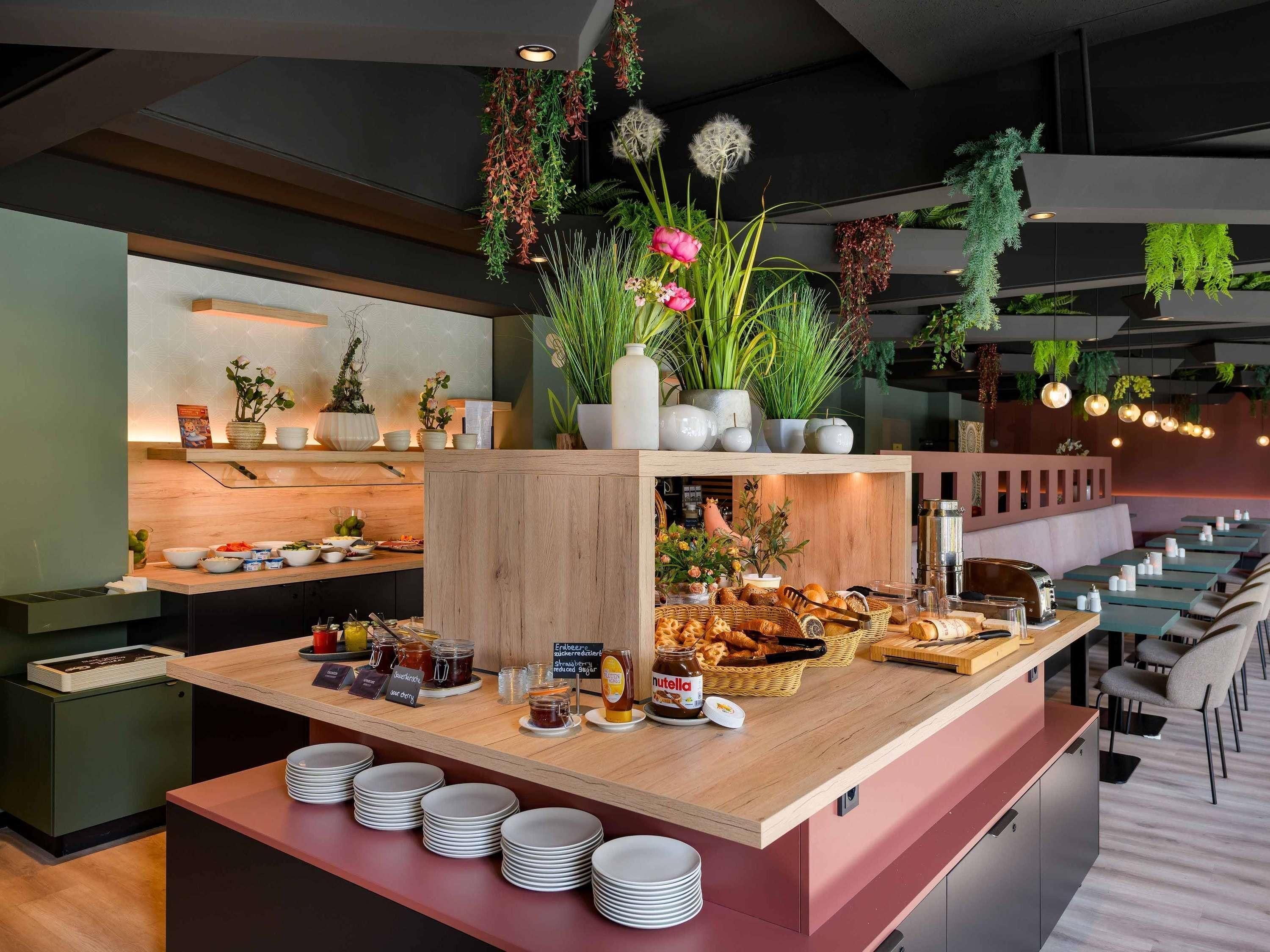 A buffet area with various food items and condiments, including jars of jam and a selection of breads.