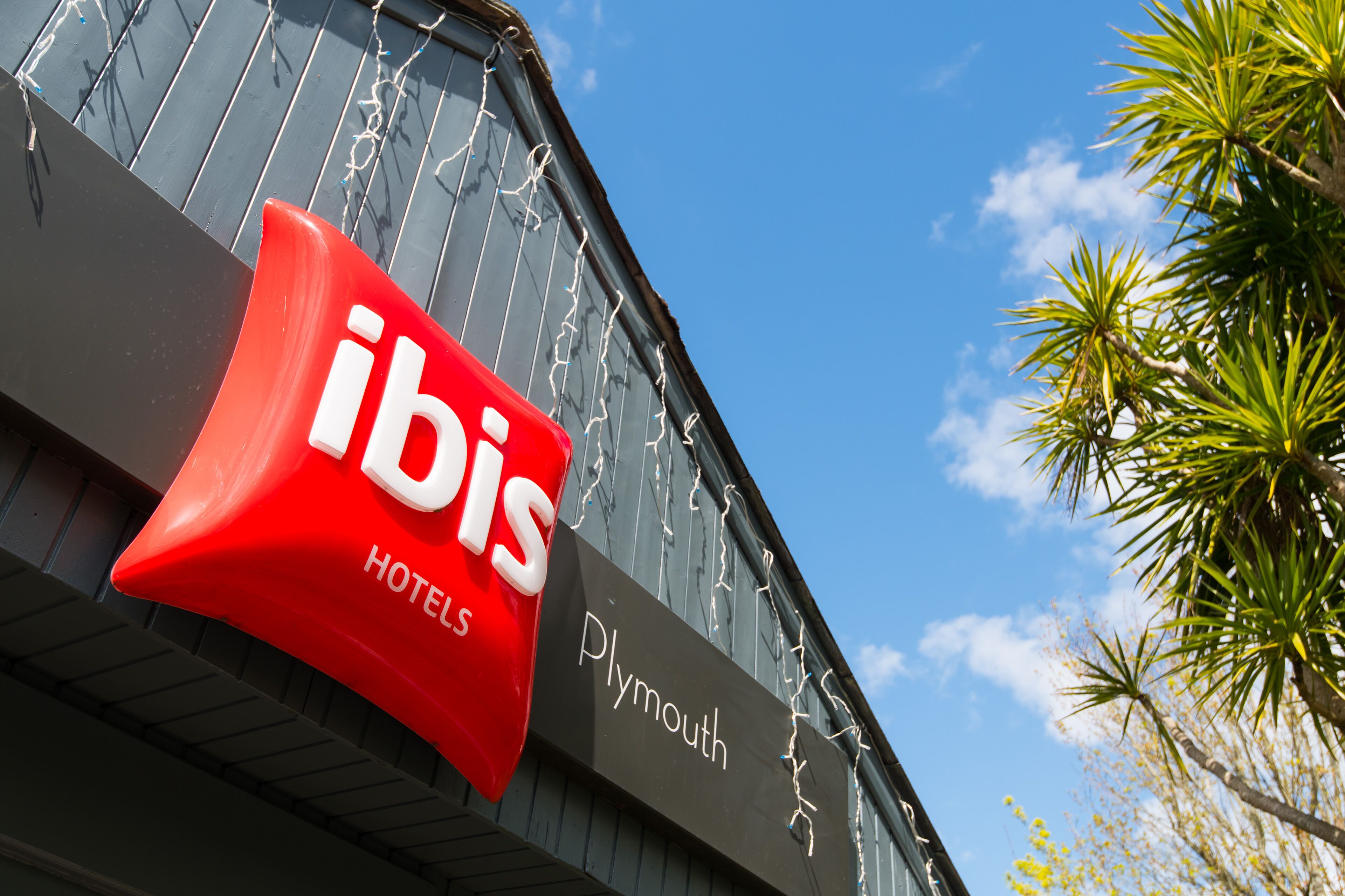 Une enseigne d’hôtel sur laquelle on peut lire les mots « ibis » et « hôtels ».