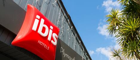 Une enseigne d’hôtel sur laquelle on peut lire les mots « ibis » et « hôtels ».