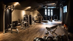 A gym with various exercise equipment, including treadmills, weight machines, and free weights. - Hotel PULSE8 (Prague)