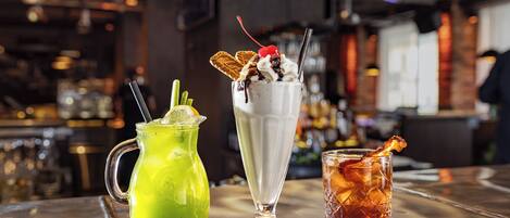Three drinks on a bar counter with a blurred background.
