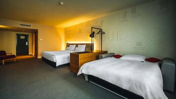 Ein Hotelzimmer mit zwei Betten, einer Holzkommode, einem Schreibtisch und einer Wand voller Karten.