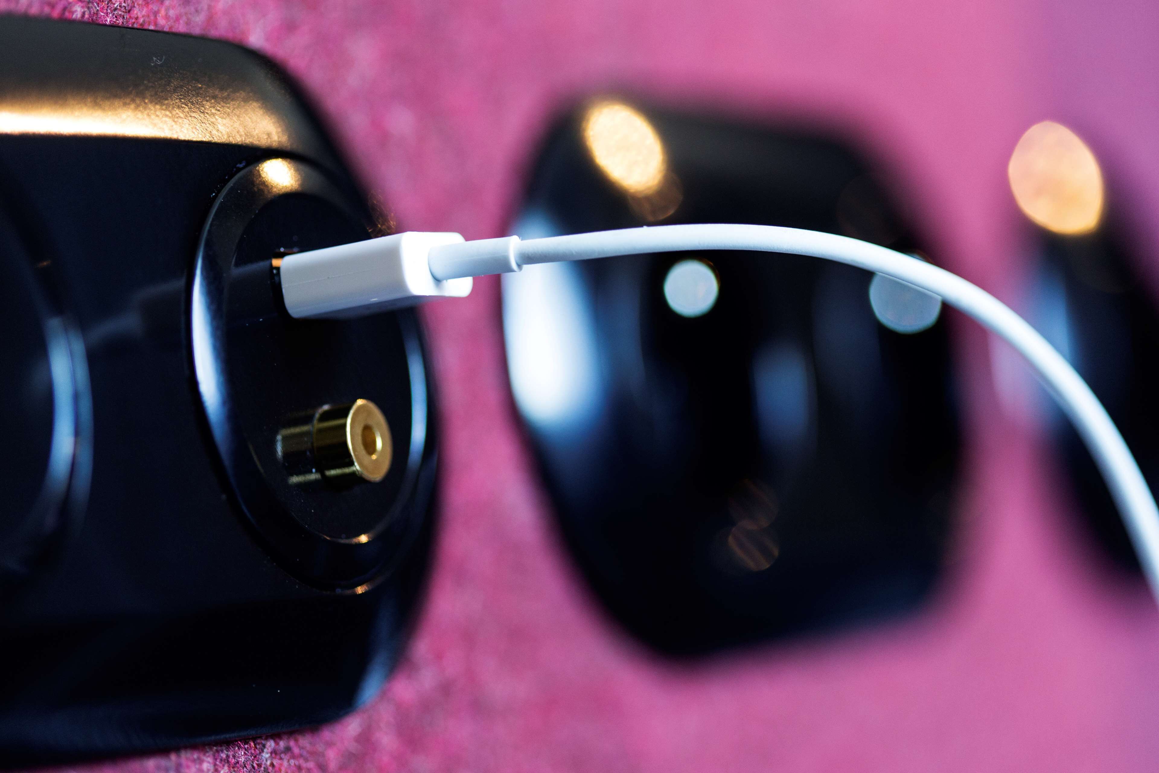 A close-up of a white charging cable plugged into a black charging port.