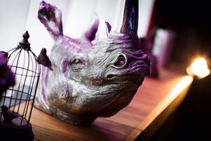 Una escultura de una criatura mitológica con cuernos y una jaula.