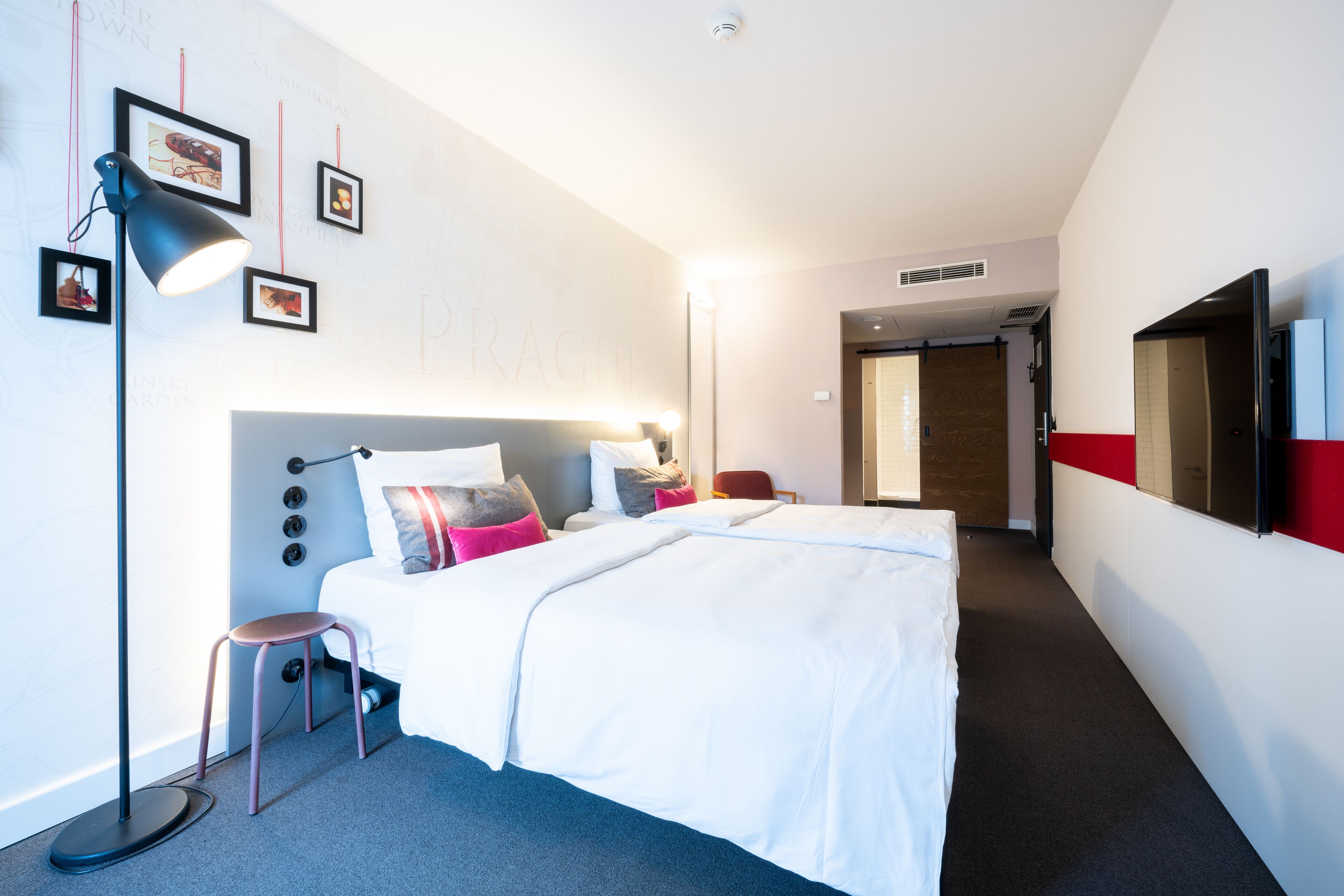 Een moderne hotelkamer met een groot bed, nachtkastjes, een bureau en een stoel.