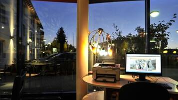 Ein Arbeitsplatz mit Computer, Drucker und Schreibtischlampe.