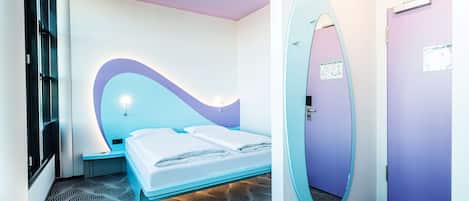 A modern hotel room with a curved headboard, a large mirror, and a patterned floor.