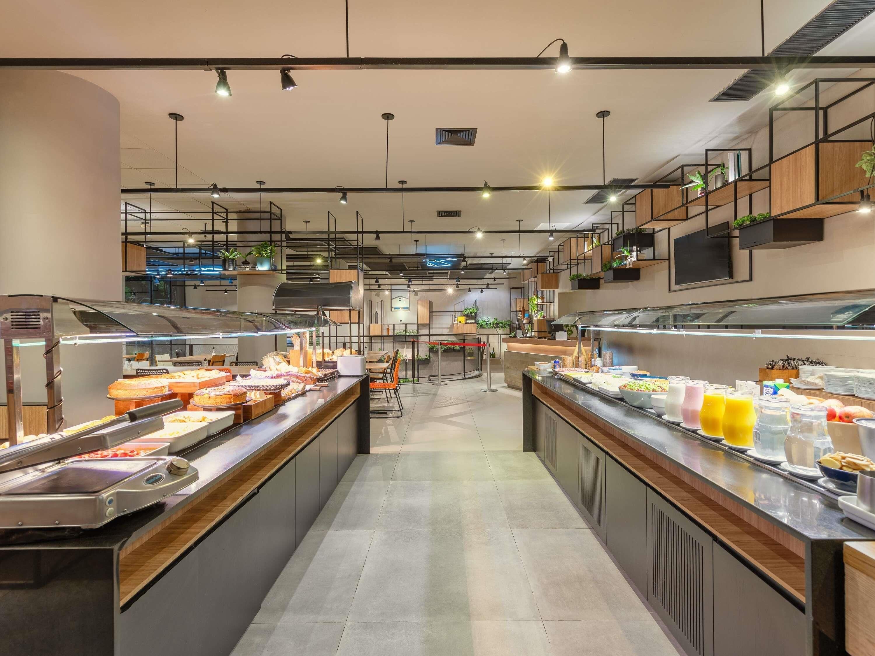 Montaje moderno de bufé con varias estaciones de comida, incluyendo una parrilla y una variedad de platos preparados.
