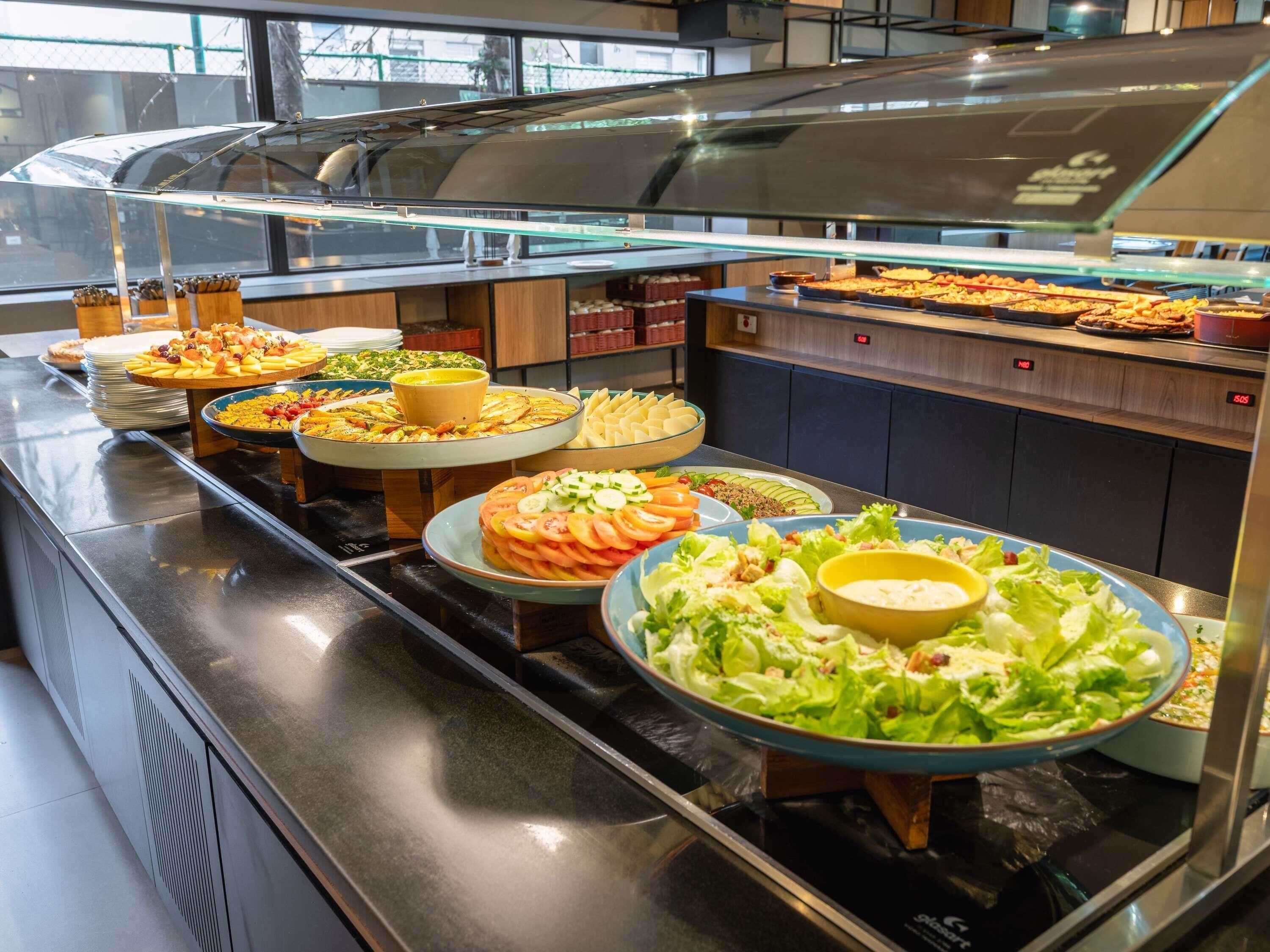 A buffet with various dishes and a salad bar.