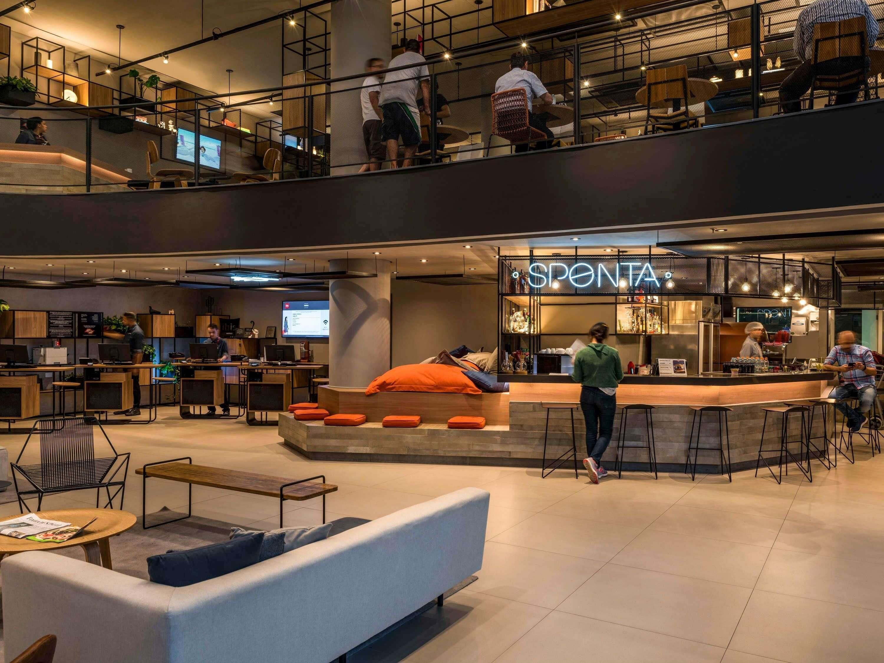 A modern interior with a bar area named 'SPONTA' and seating arrangements.