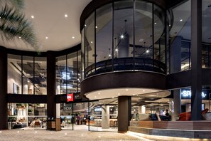 A modern indoor shopping area with glass railings, a central atrium, and various retail stores. - ibis São Paulo Barra Funda (São Paulo)
