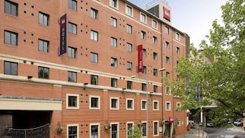 A multi-story hotel with a brick facade, multiple windows, and a visible entrance.
