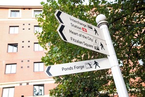 A directional signpost with arrows pointing towards Interchange Station, Heart of the City, Fishtalian Square, and Ponds Forge. - ibis Sheffield City (Sheffield)