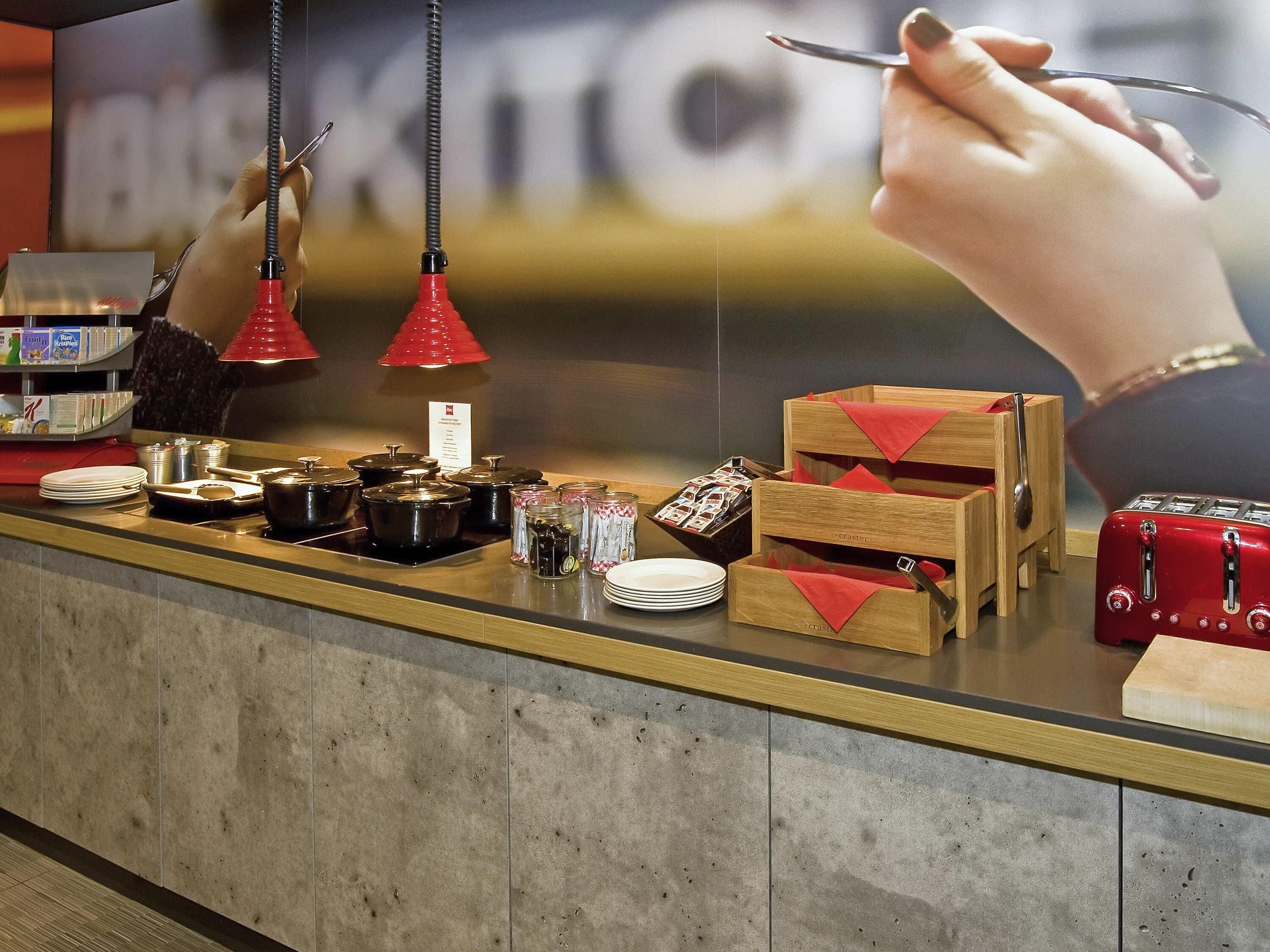A breakfast buffet with various food items, condiments, and utensils.
