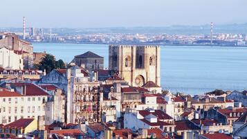 A coastal cityscape with historic buildings and a prominent tower by the waterfront.