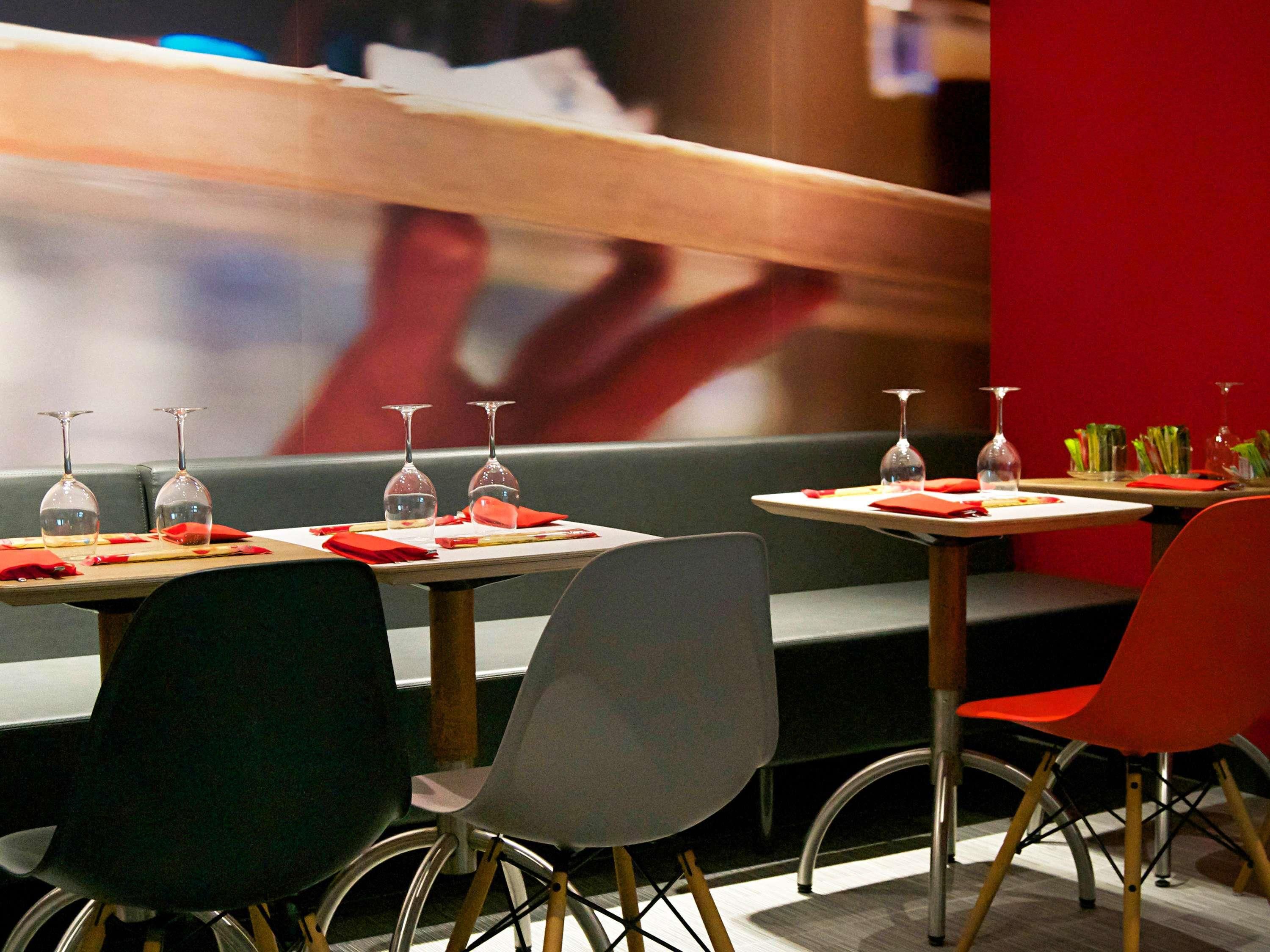 A restaurant interior with tables set for dining, chairs, and wine glasses.