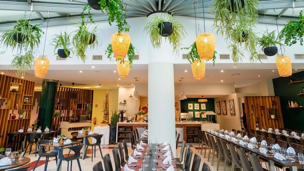 A spacious indoor dining area with multiple tables and chairs, hanging plants, and a modern ceiling design. - ibis Antananarivo Ankorondrano (Antananarivo)