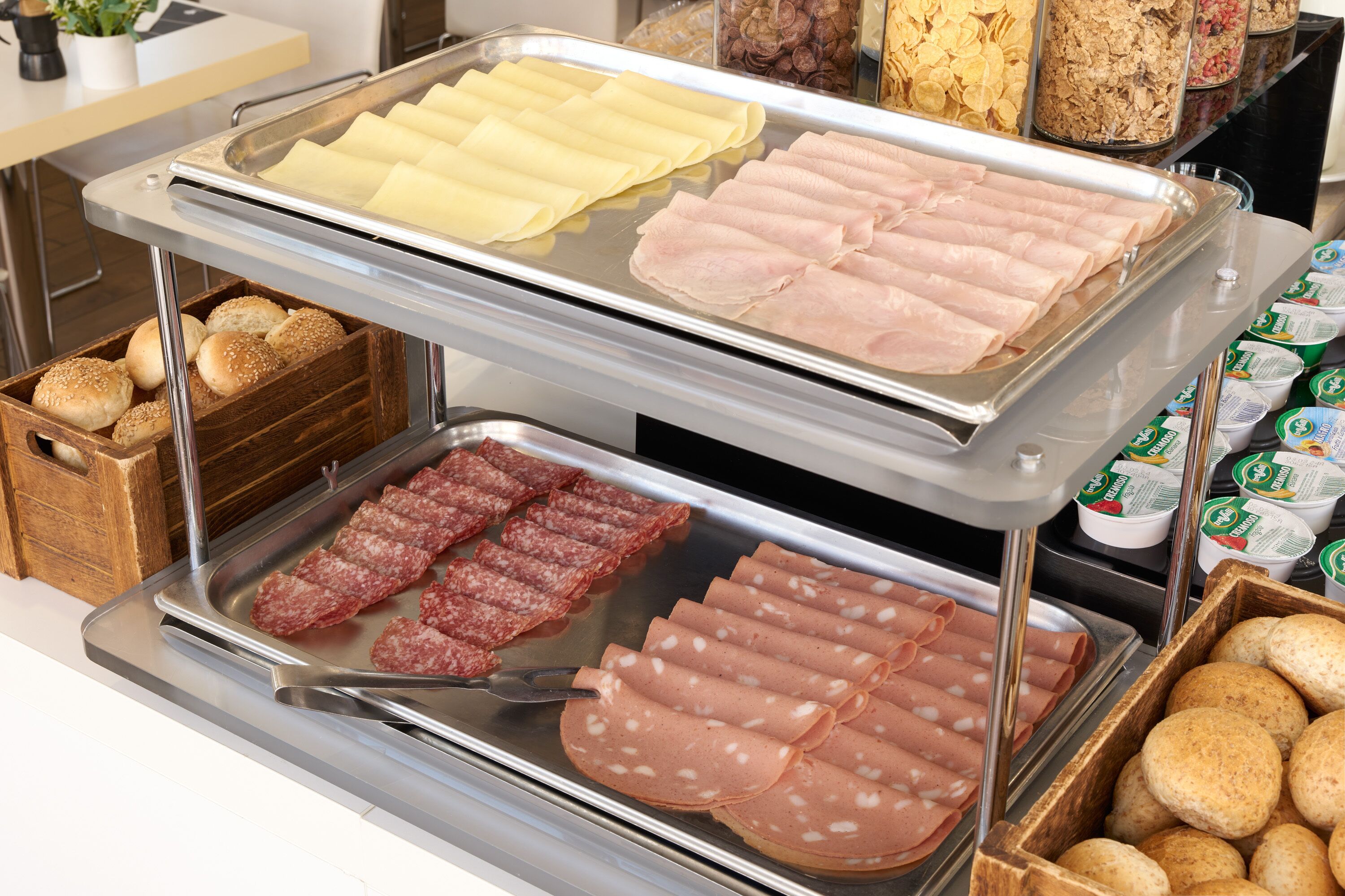 A buffet with various food items including sliced meats, cheeses, and bread.