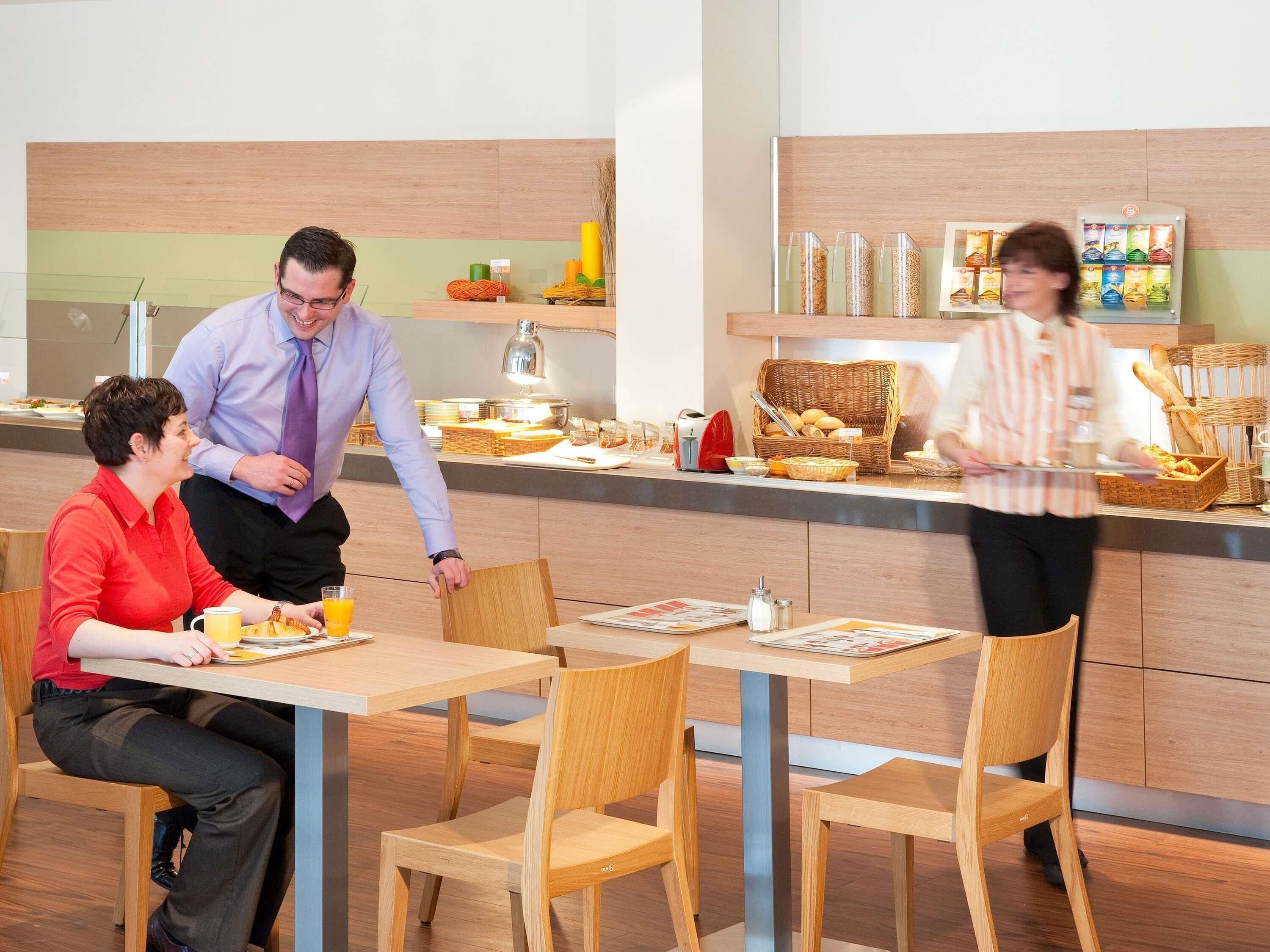 Un comedor moderno con mobiliario de madera y una barra para buffet.