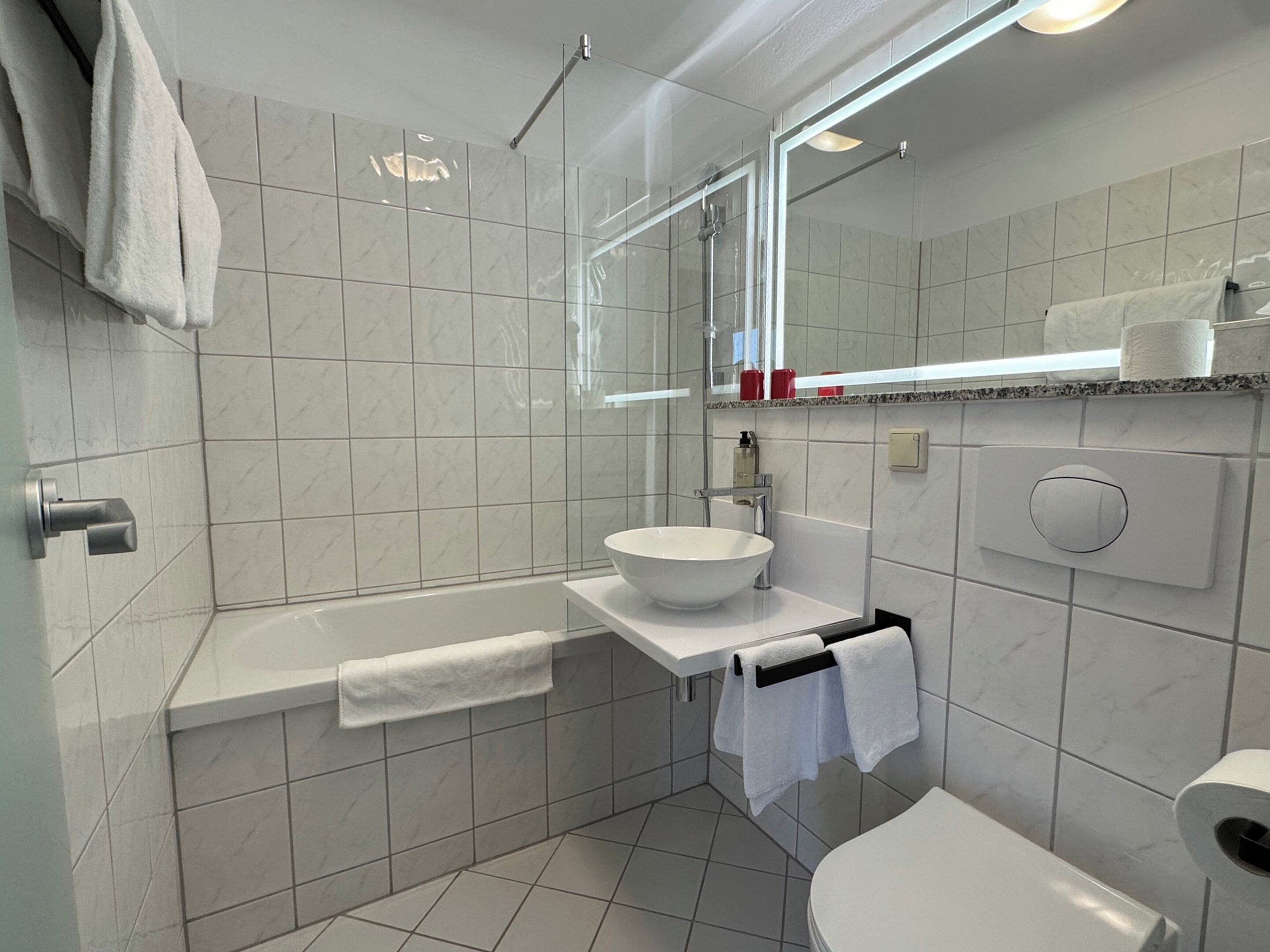 Un baño moderno con bañera, lavamanos e inodoro.