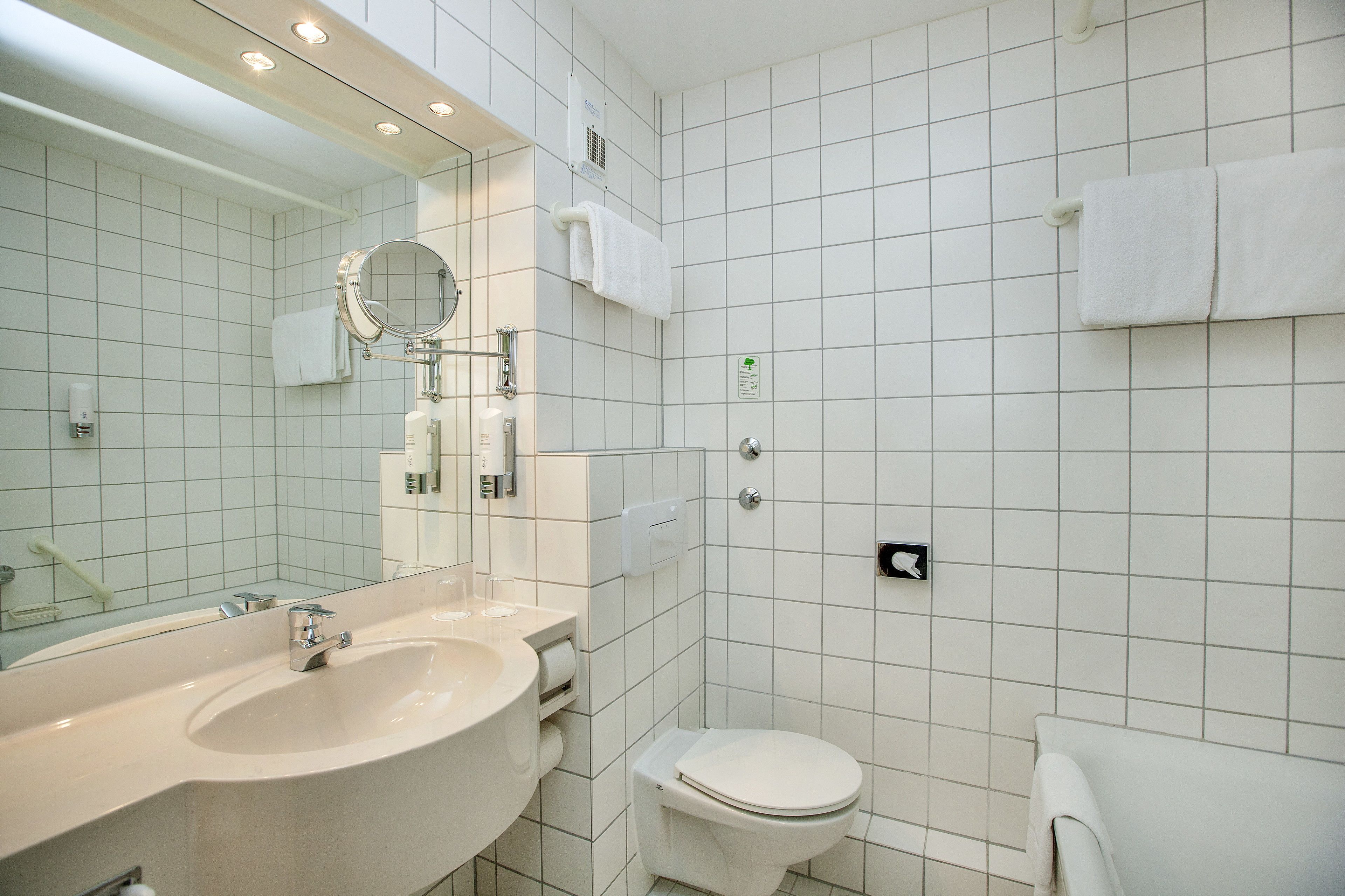 Une salle de bain moderne avec un grand lavabo, un miroir et des toilettes.