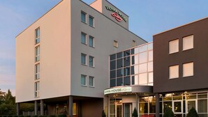A Vienna House hotel with a modern facade, large windows, and a well-lit entrance. - Vienna House Easy by Wyndham Amberg (Amberg)