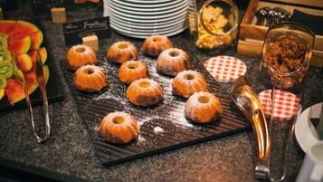 A dessert display with various pastries and fruits.