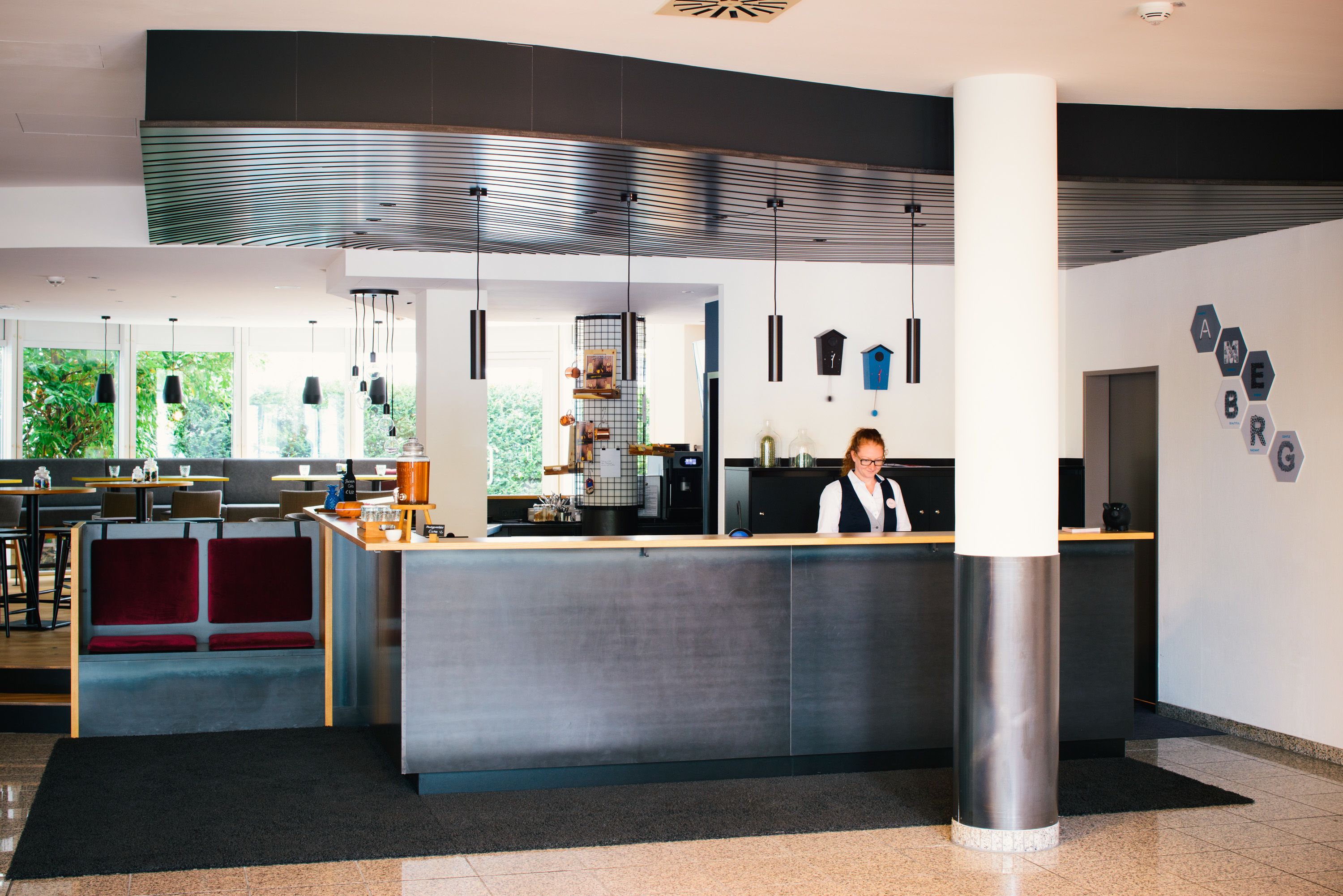 A modern reception area with a counter, seating, and a view of the outdoors.