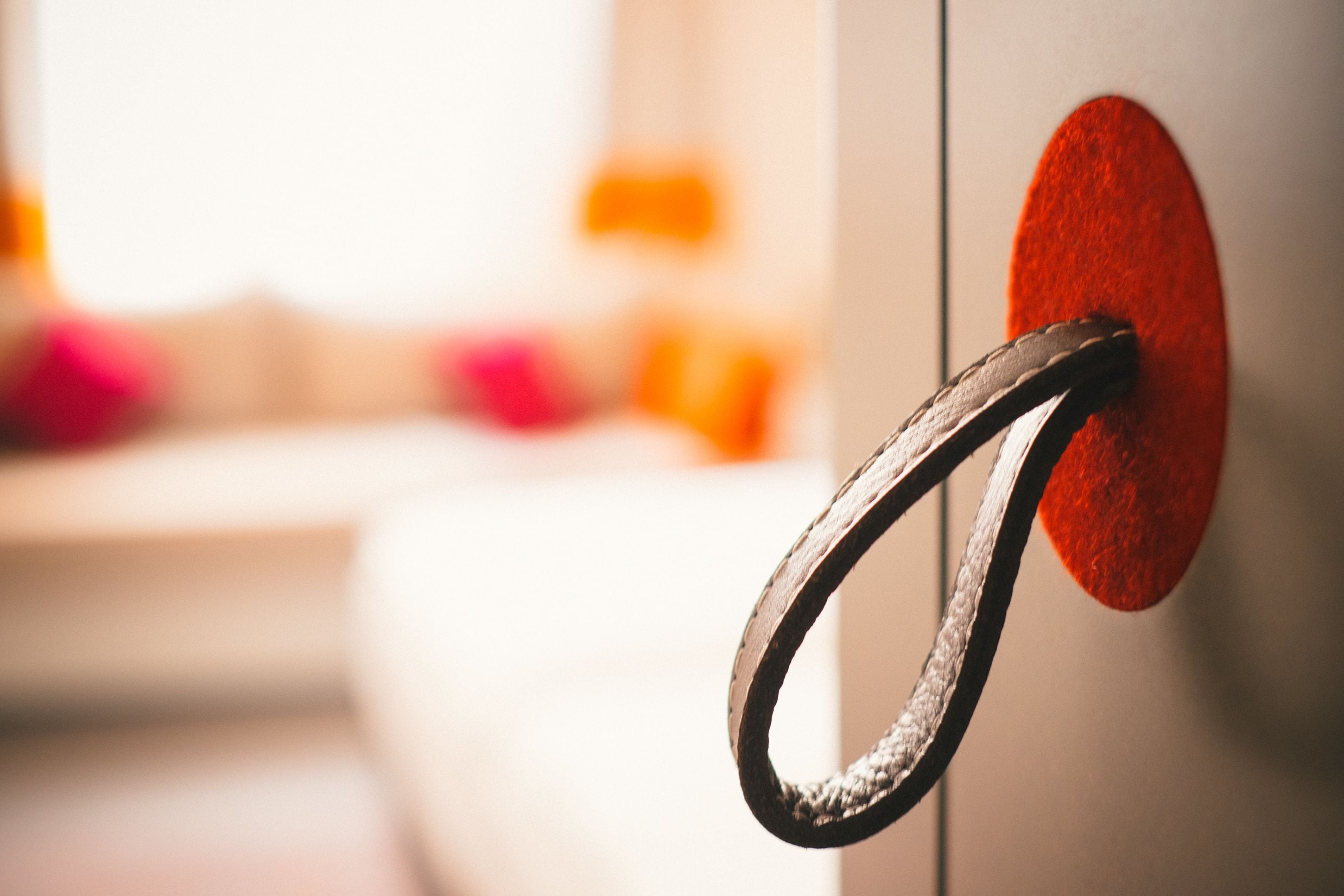 A metal handle attached to a wall with a red circular object.