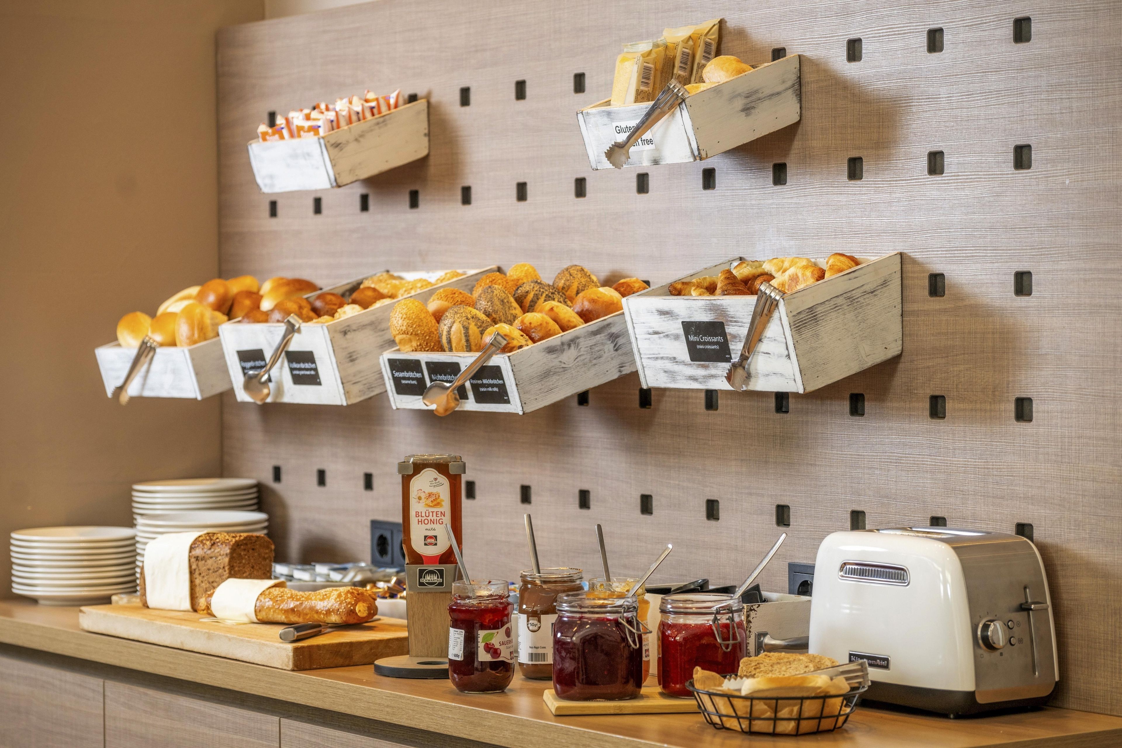 A breakfast buffet with various pastries, bread, and condiments.