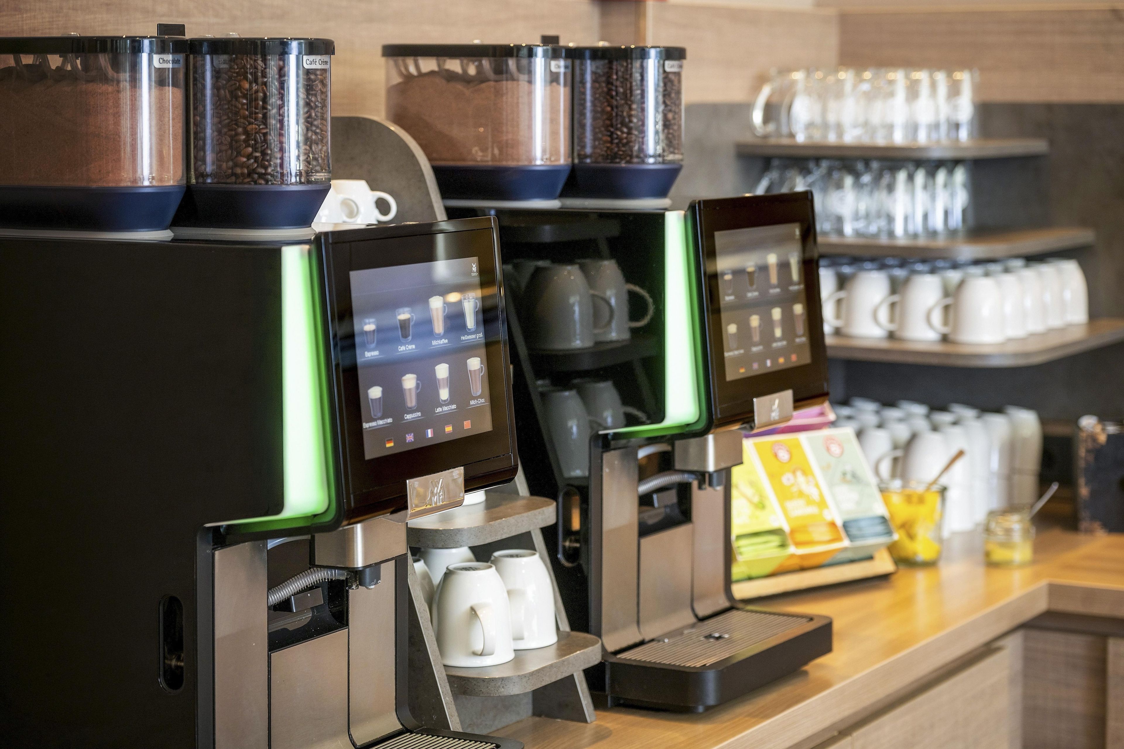 Eine Kaffeemaschine mit verschiedenen Zubereitungsmöglichkeiten und einem Behälter für Kaffeebohnen.