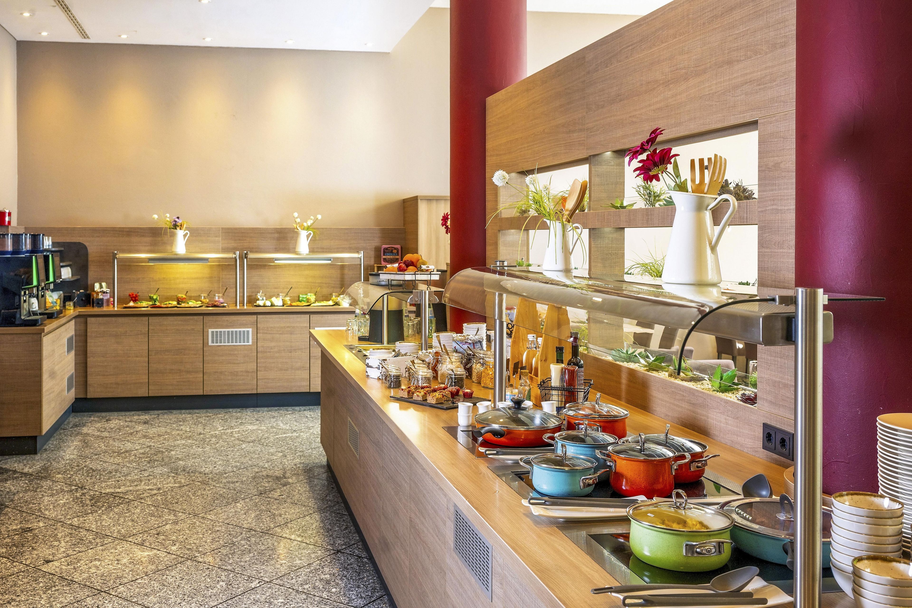 A buffet area with a variety of food items, a coffee station, and a counter with utensils.