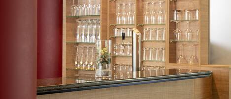 A bar area with shelves of glasses and a tap.