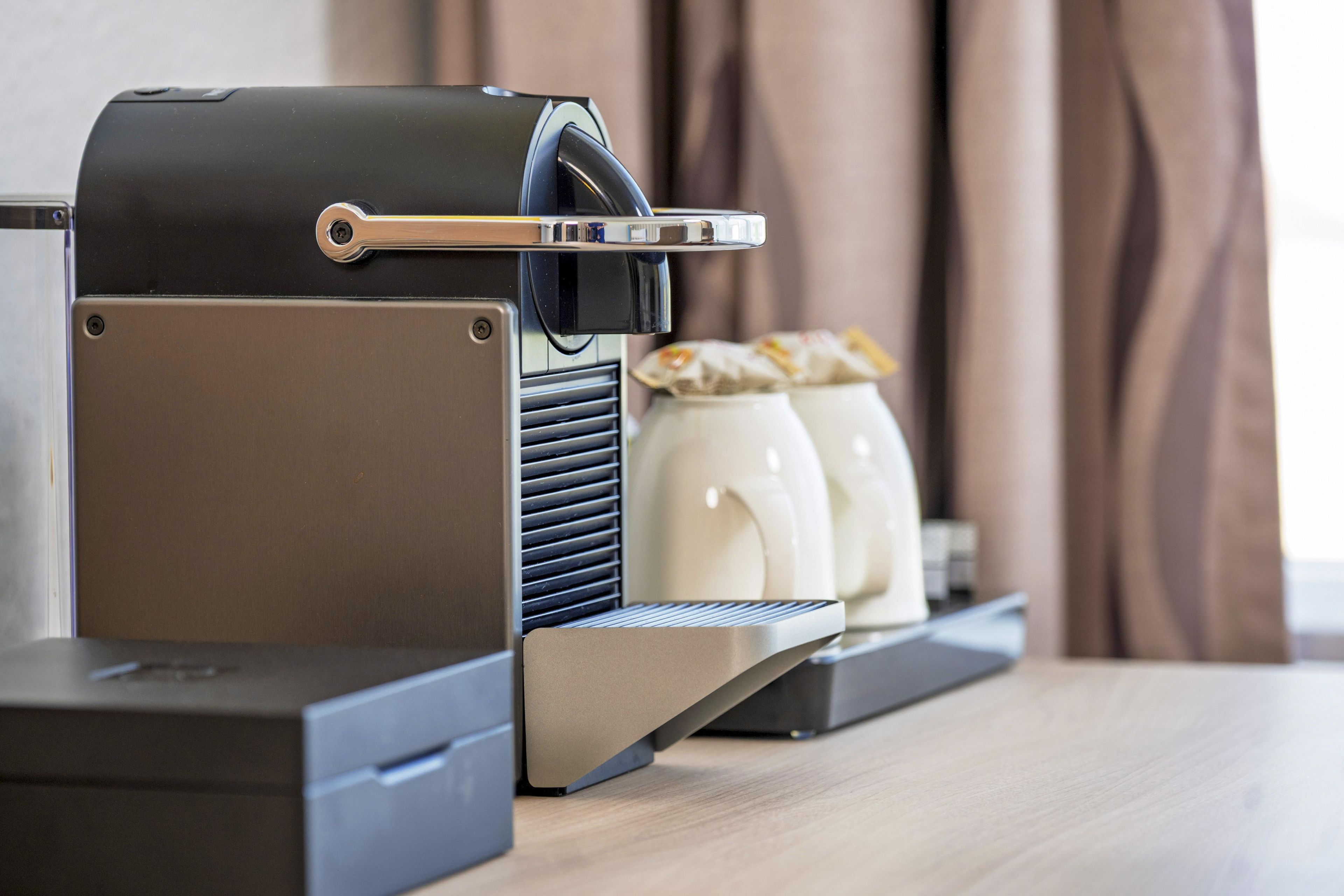 A coffee machine with a built-in grinder and a tray for coffee cups.