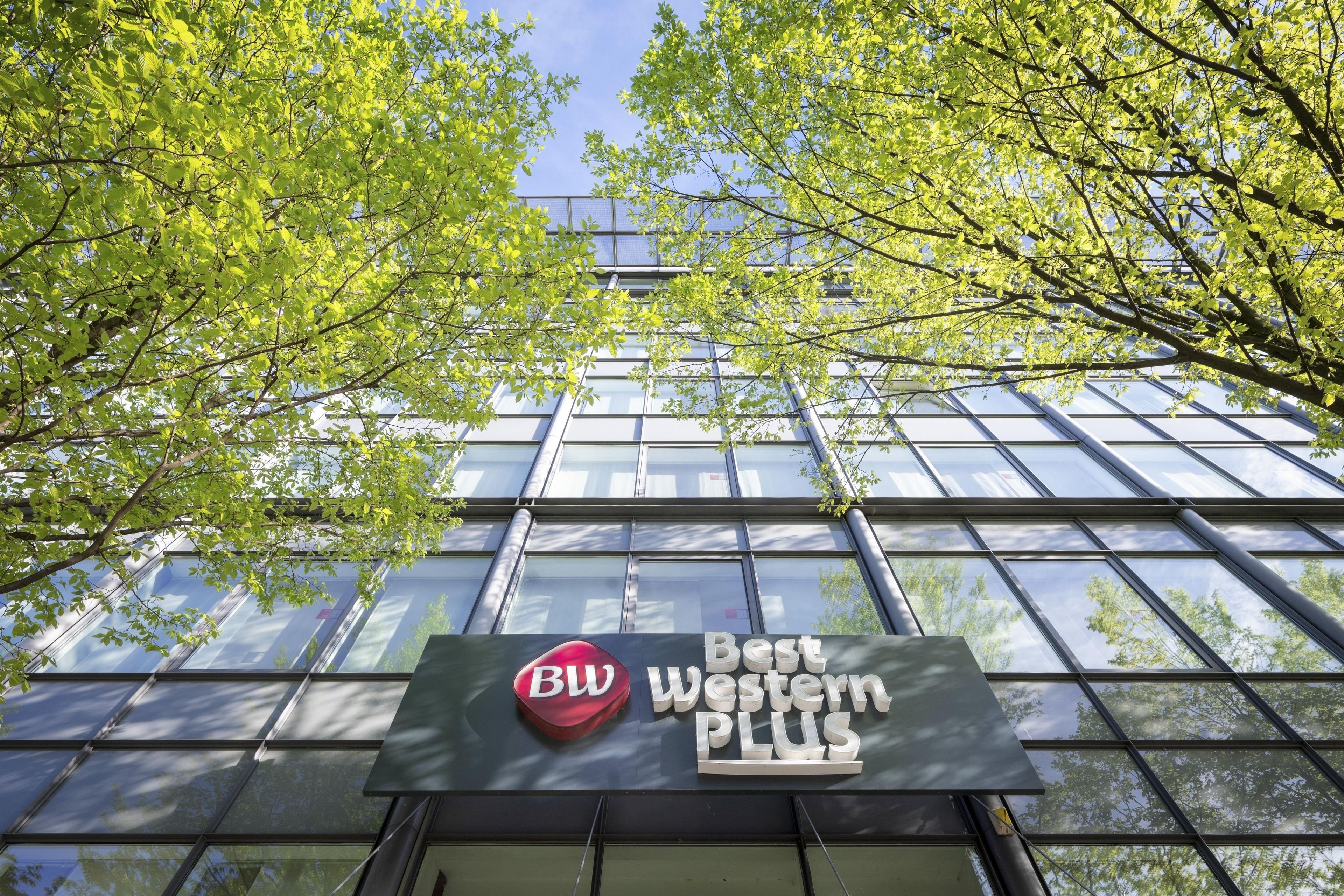 A building with a large glass facade and a sign that reads 'BW Best Western PLUS'.