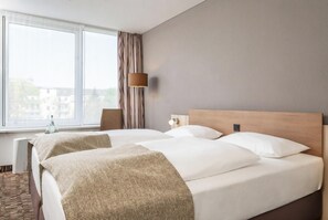 A hotel room with a large window, a bed with white linens, a wooden headboard, and a bedside lamp. - Best Western Plus Hotel Dresden City (Dresden)