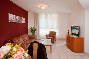 Suite Deluxe, balcón, vista al mar | Área de sala de estar | Televisión 