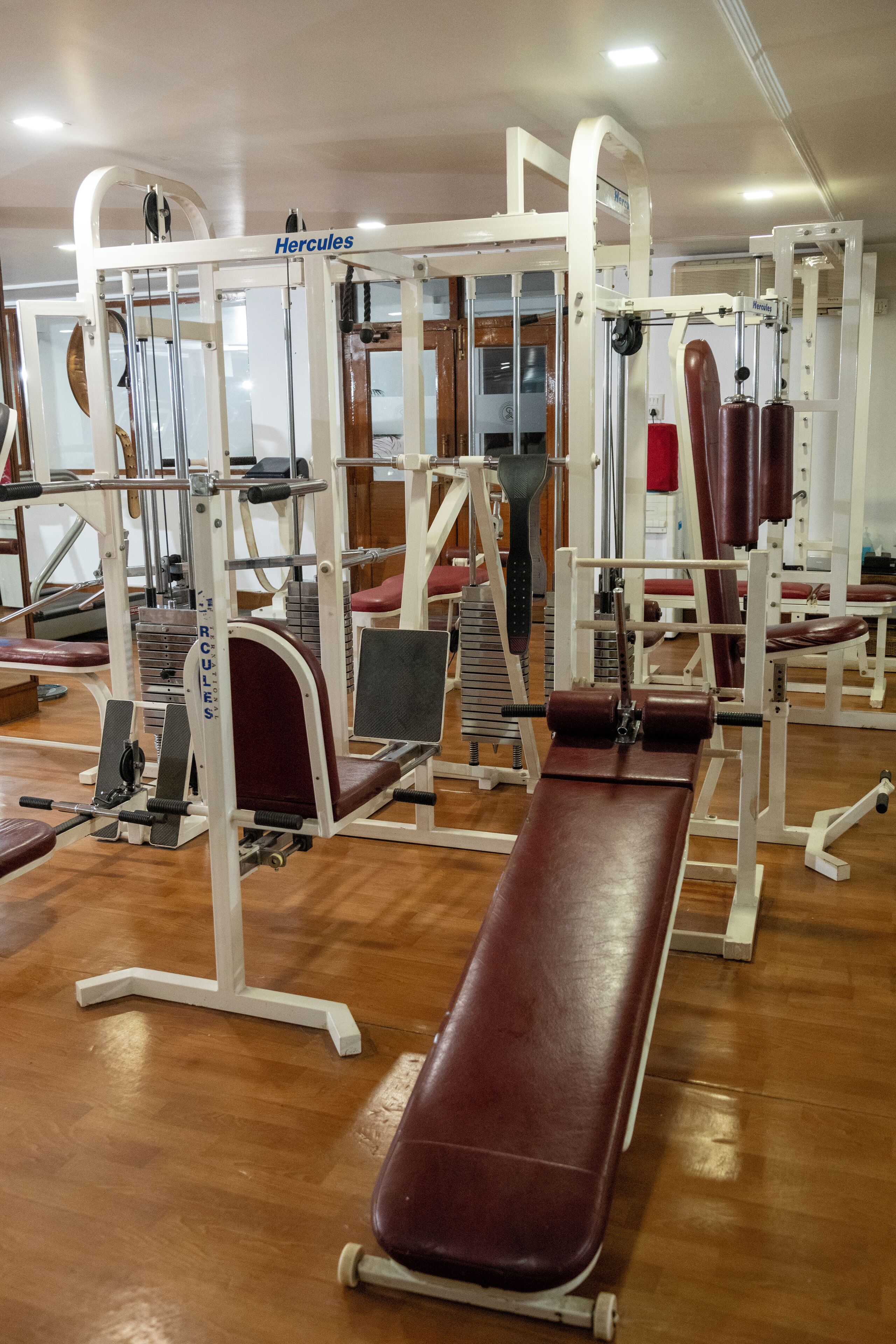 Un gimnasio con diversos equipos de ejercicio, incluidas pesas y máquinas de entrenamiento.