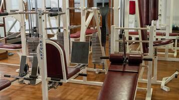 Un gimnasio con diversos equipos de ejercicio, incluidas pesas y máquinas de entrenamiento.
