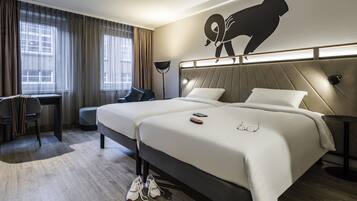 Una habitación de hotel moderna con una cama grande, un escritorio y una silla.