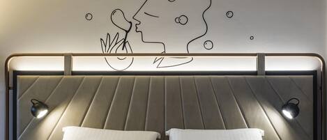 Un dormitorio moderno con cabecera, dos lámparas de noche y una obra de arte en la pared de un jinete y su caballo.