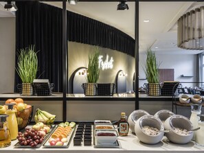 Buffet de l'esmorzar amb fruites, begudes i un rètol de neó.