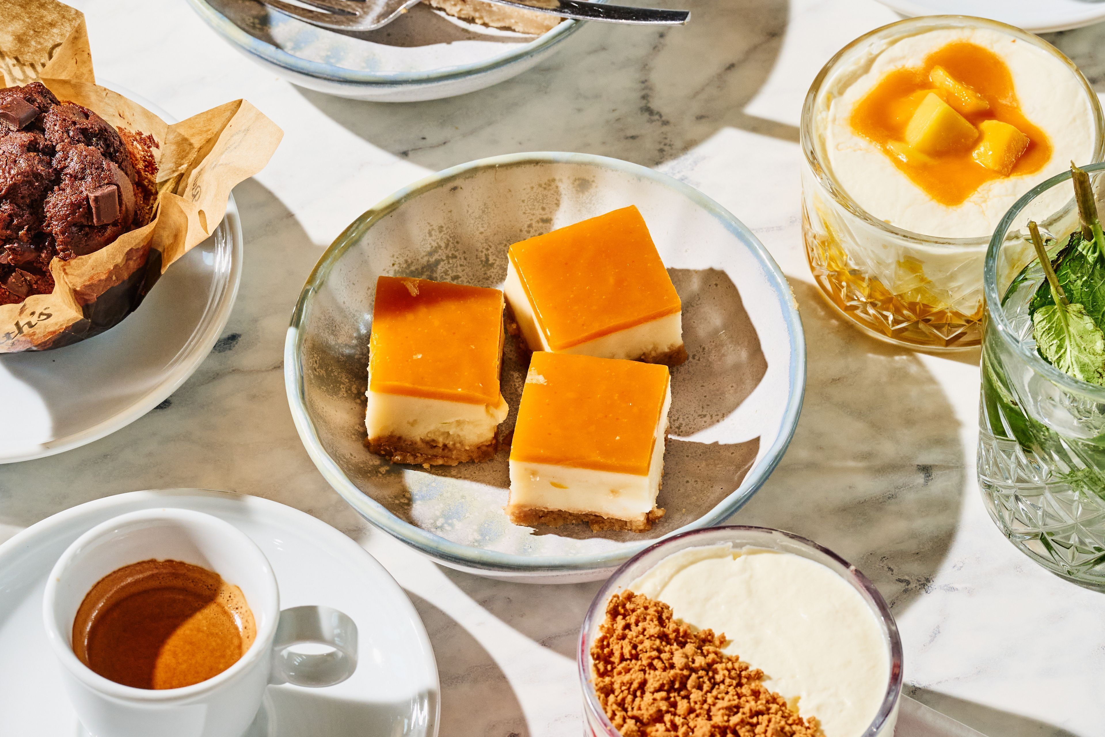 Una mesa de postres con diversos dulces y bebidas.