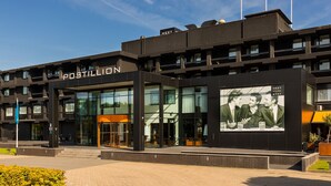 A modern building with the name "POSTILLION" prominently displayed. - Postillion Hotel Dordrecht (Dordrecht)