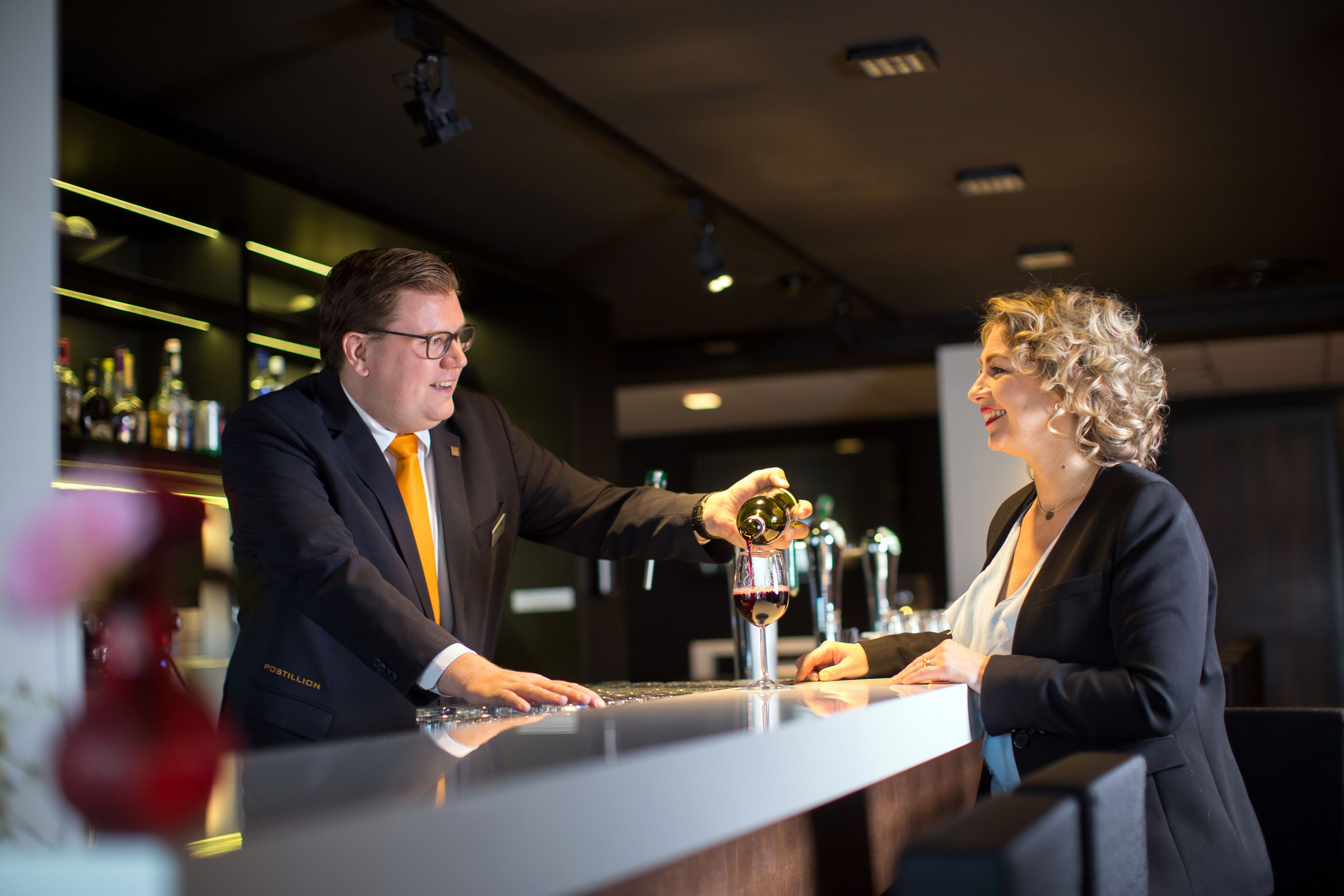 A bar setting with a bartender and a customer.