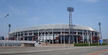 Un estadio grande y moderno con techo curvo y varios niveles de asientos.