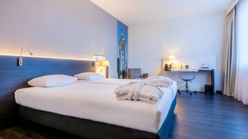 Een hotelkamer met een groot bed, een bureau en een stoel.